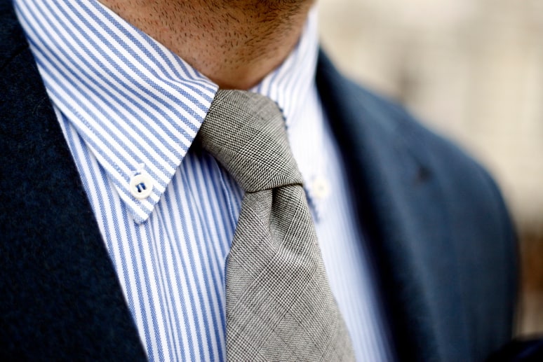 Een close-up van een man met een blauw overhemd en stropdas