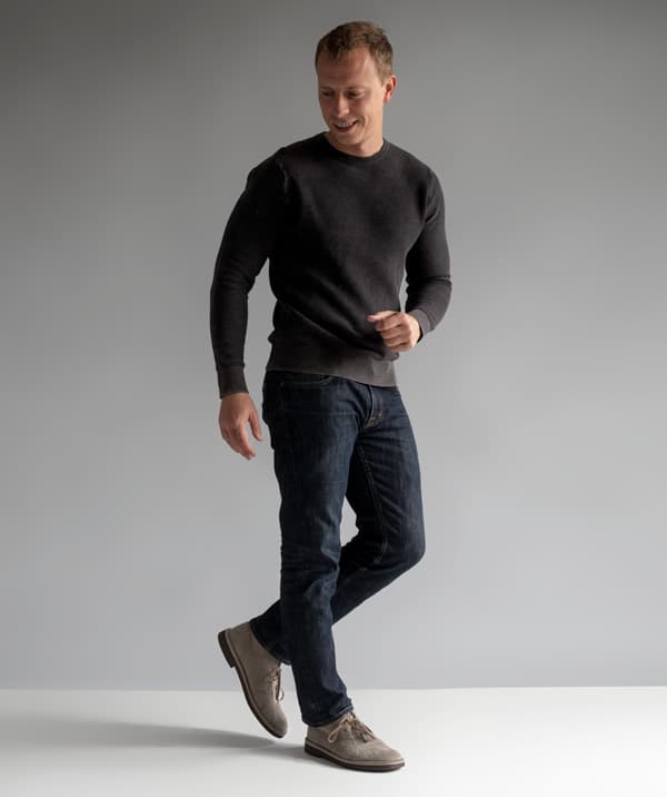 a man wearing a thermal long sleeve shirt over slim fit pants and casual shoes
