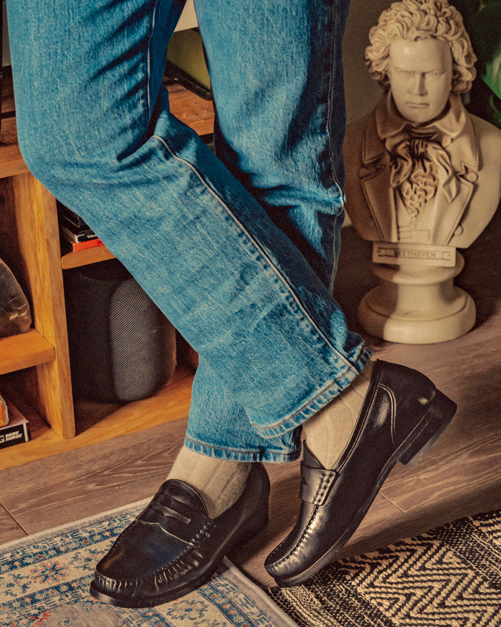 close up of black loafers with light socks and light blue wash jeans