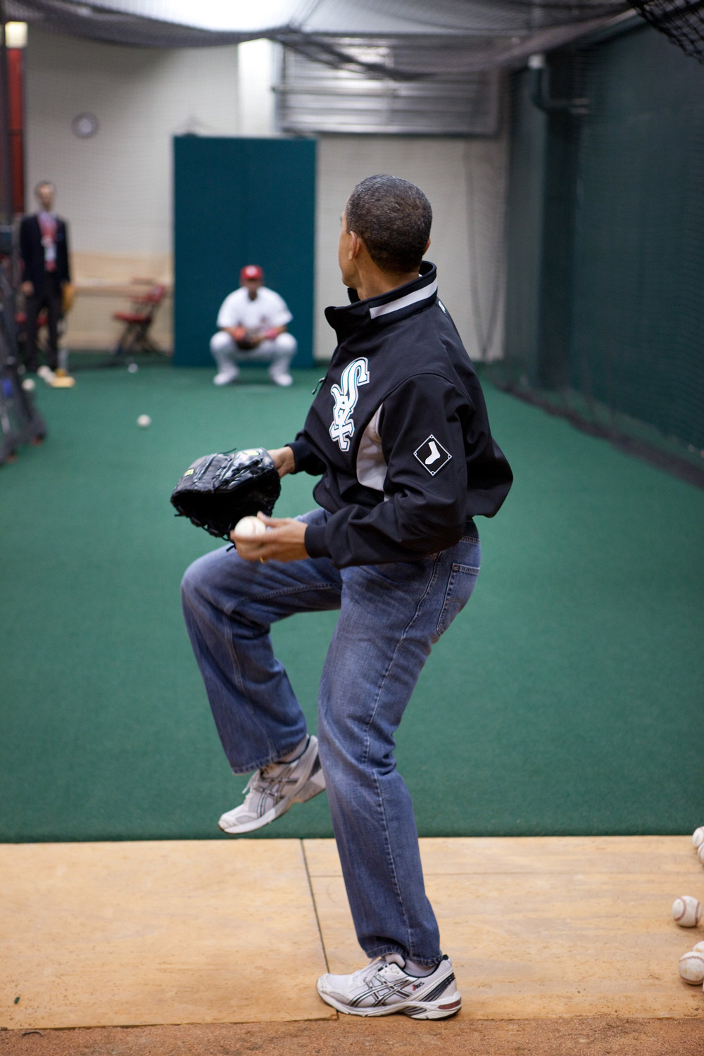 obama practicing a pitch in light wash baggy jeans