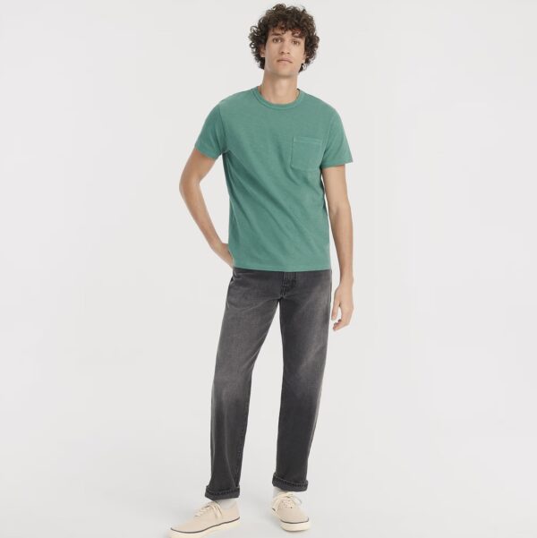a man wearing straight fit jeans with a crew neck short sleeve shirt and casual sneaker shoes