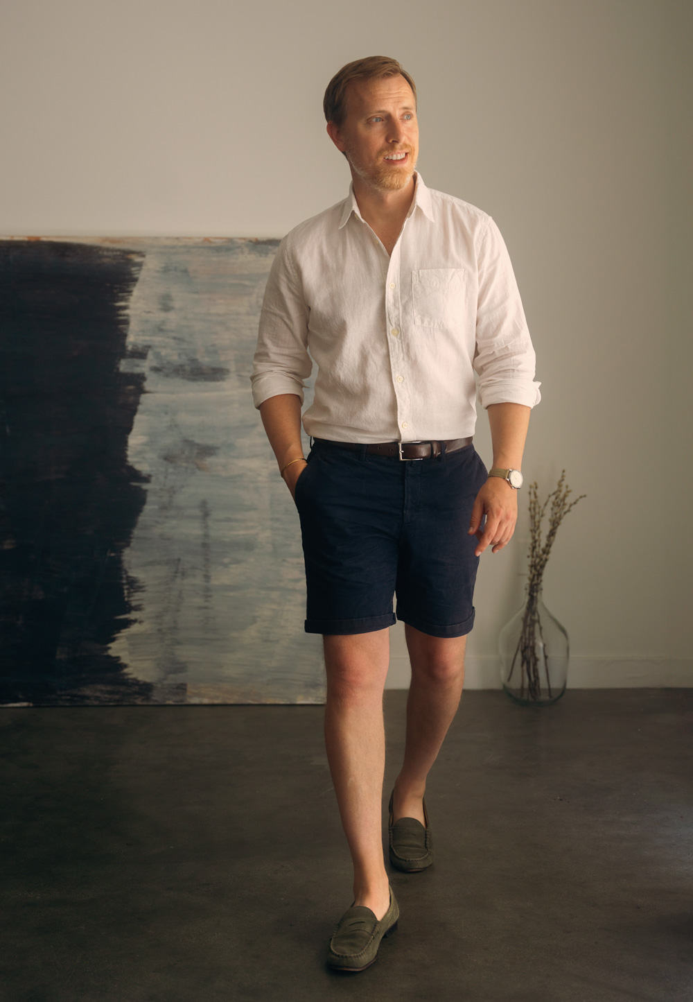 Andrew wearing a linen shirt with navy shorts and green loafers