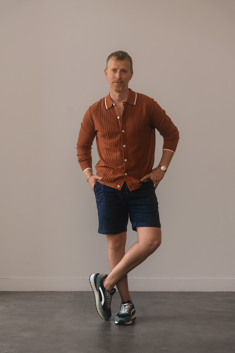 running sneakers with orange knit polo and navy shorts