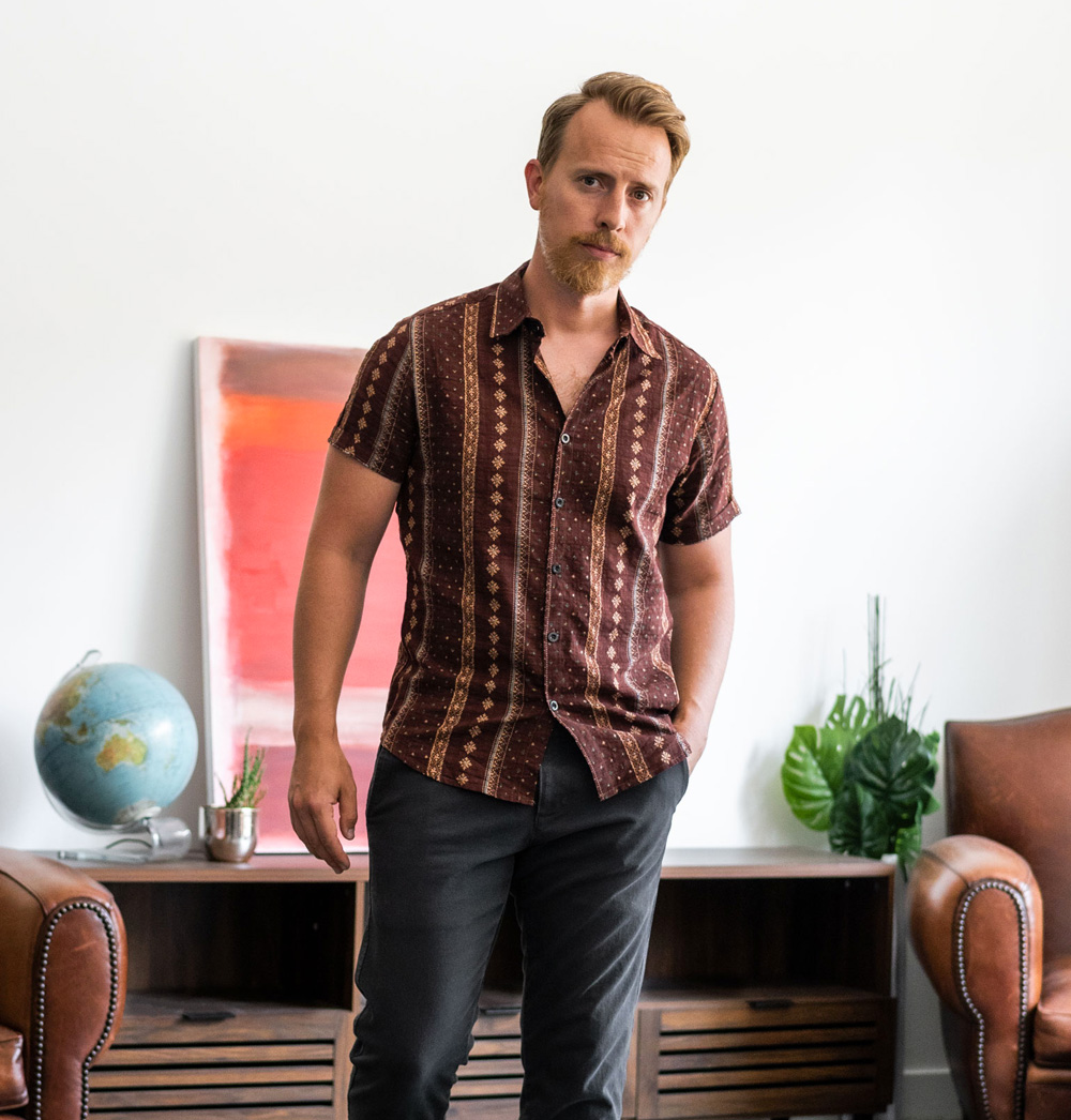 andrew wearing a short sleeve button up with a retro-inspired pattern on it